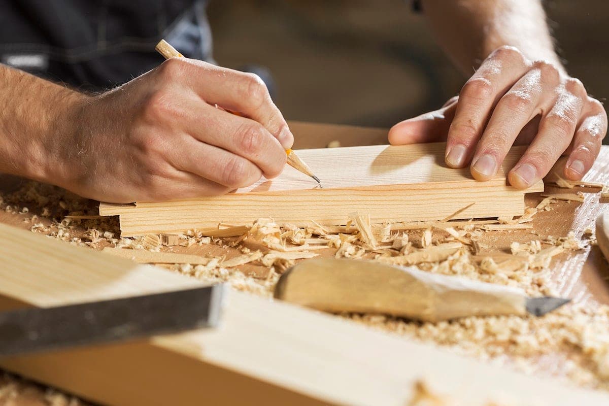 A pencil line on the board, shavings and chisel