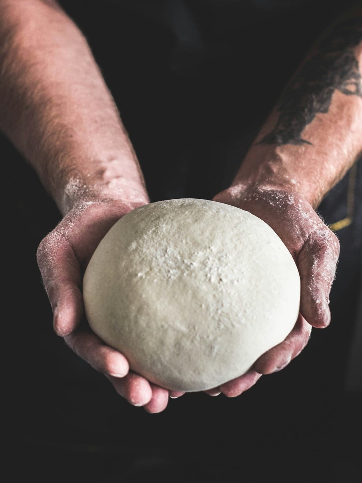 A ball of dough in floured hands