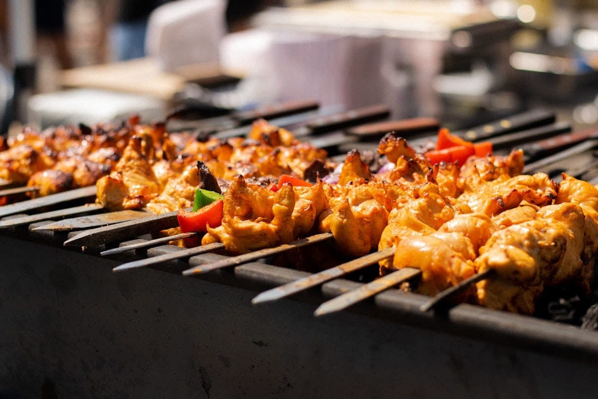 A row of chicken and pepper skewers