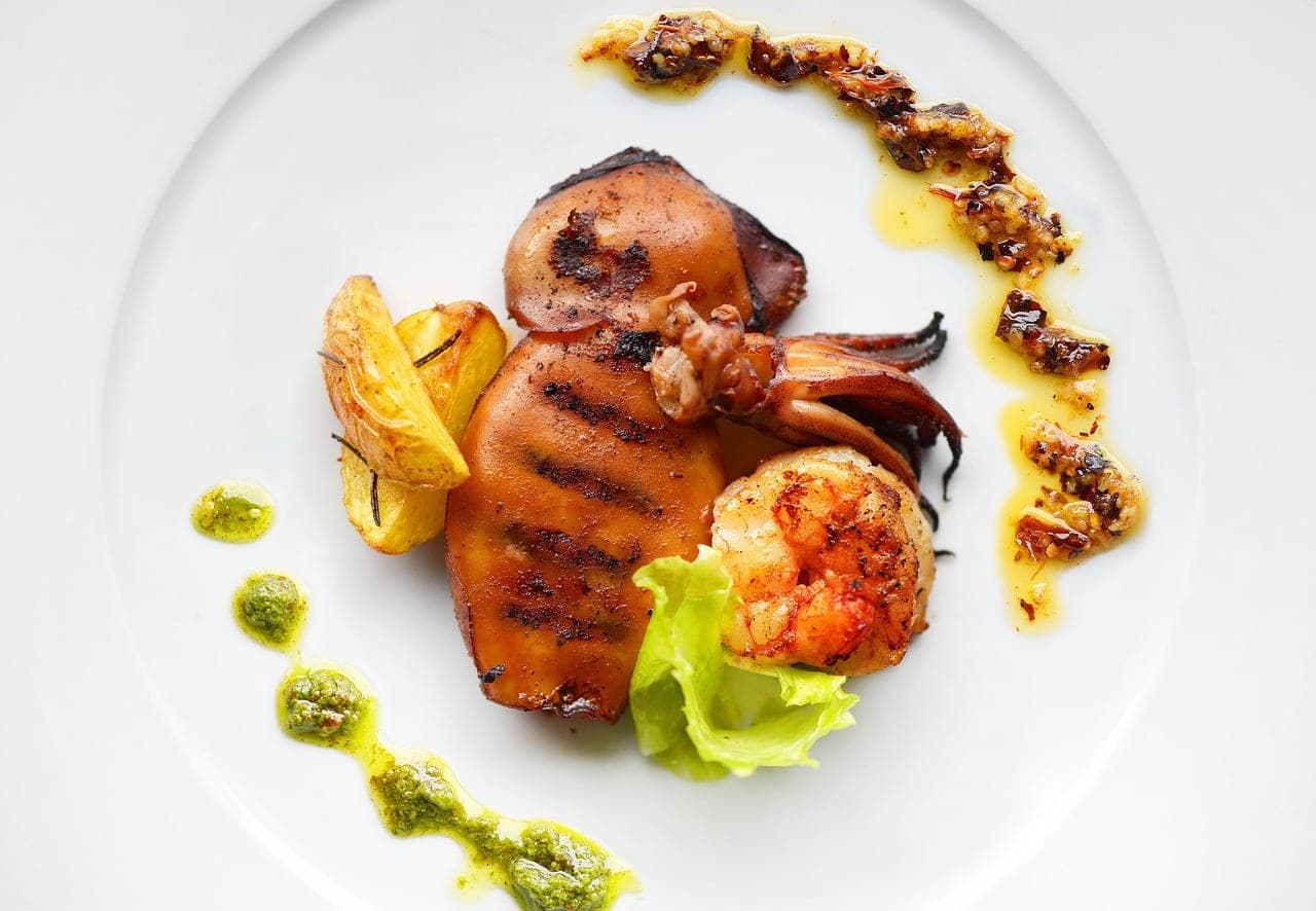 Grilled squid and a prawn, with a roasted lemon wedge.