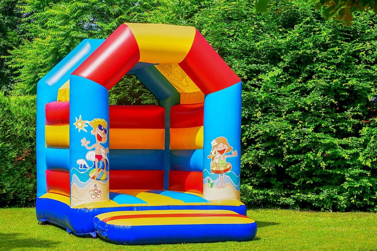 A brightly coloured bouncy castle standing on the grass.