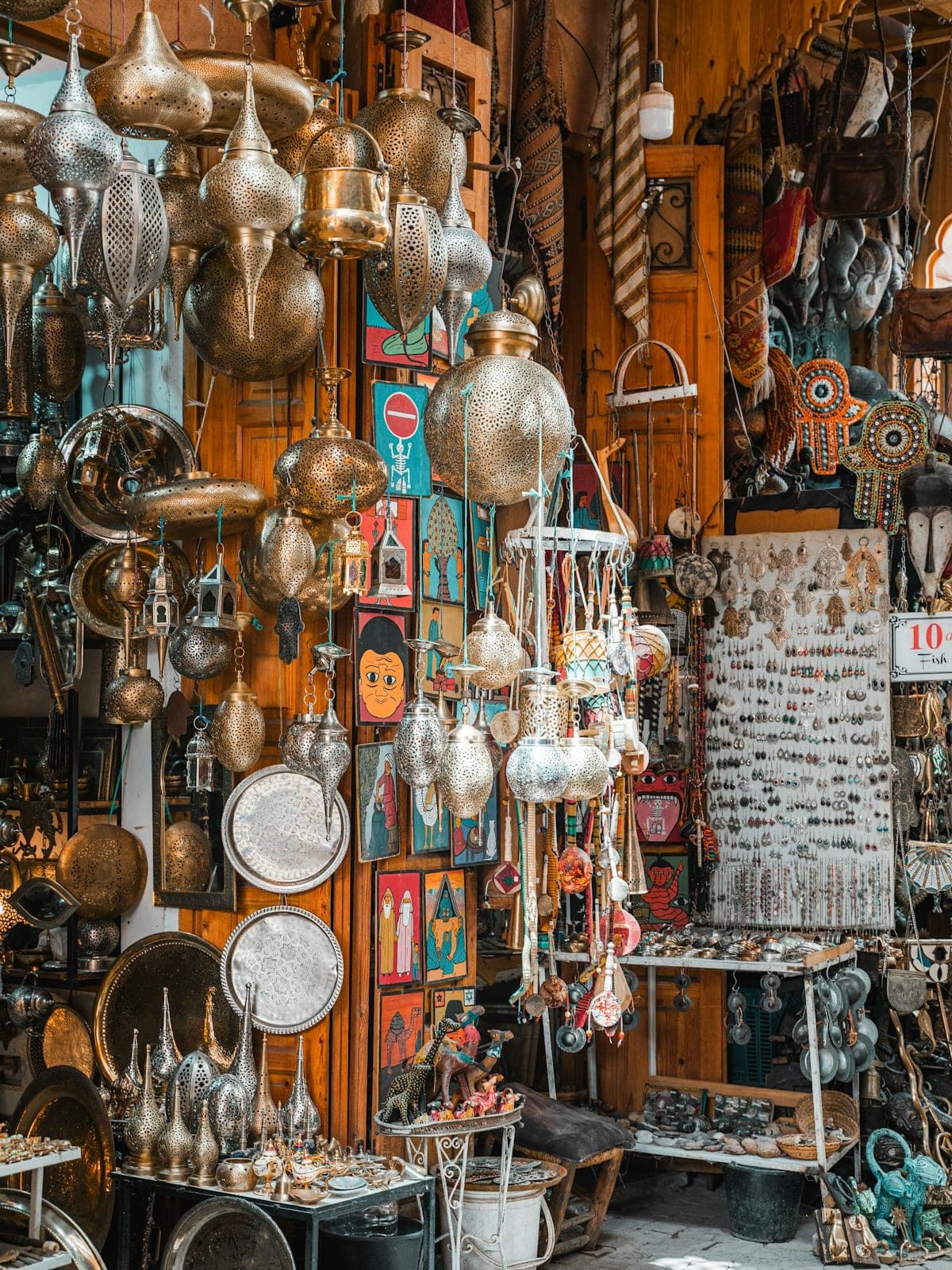 A stall loaded with brassware, trays and trinkets