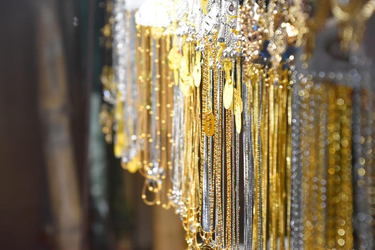 Gold and silver chains hanging, each with its price tag.