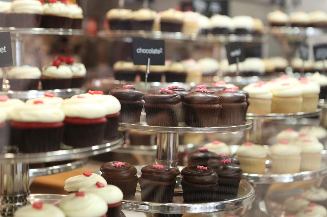 Chocolate- and cream-frosted cupcakes on tiered display stands.