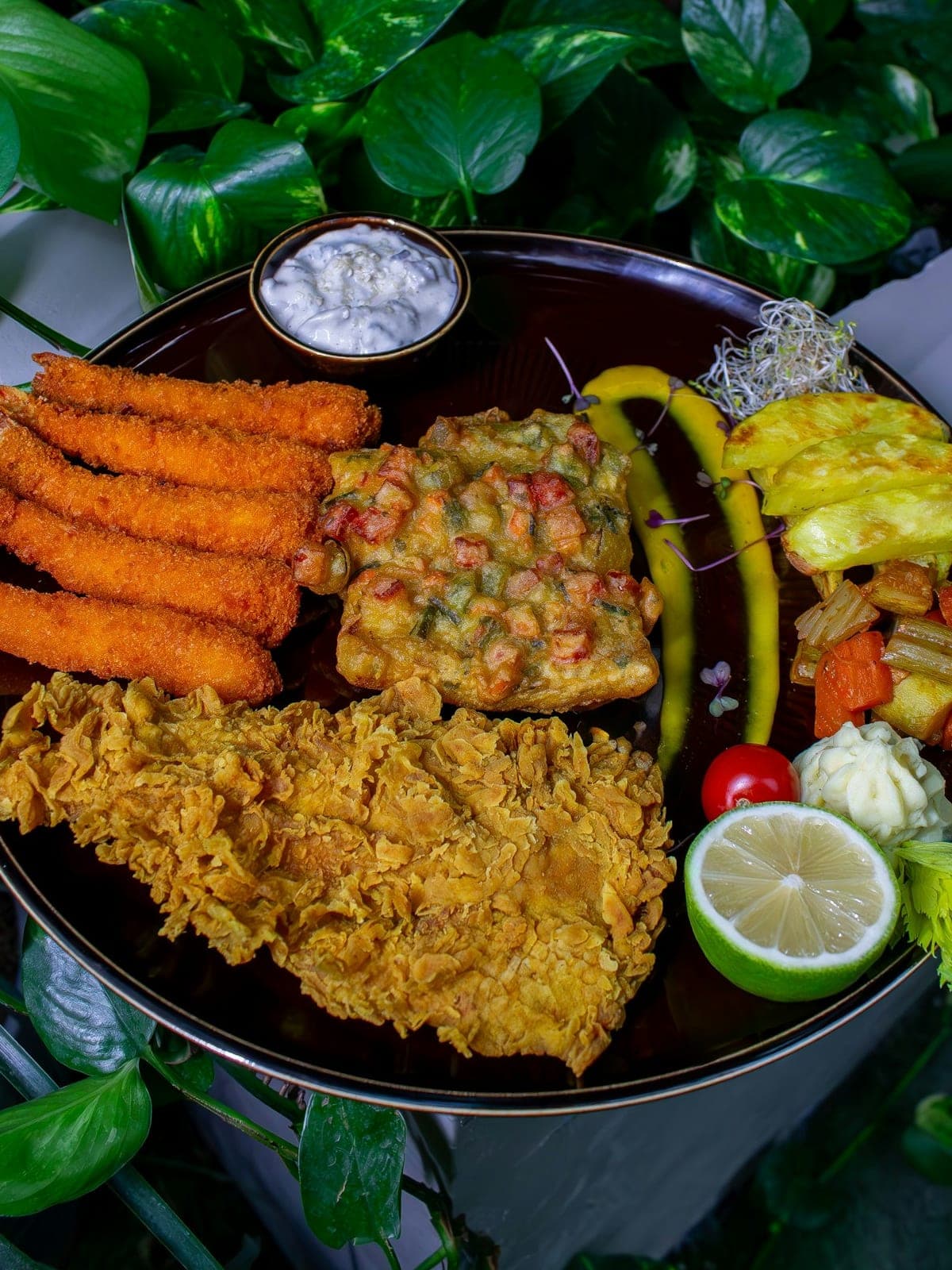 A platter of fried fish, rice and small salads
