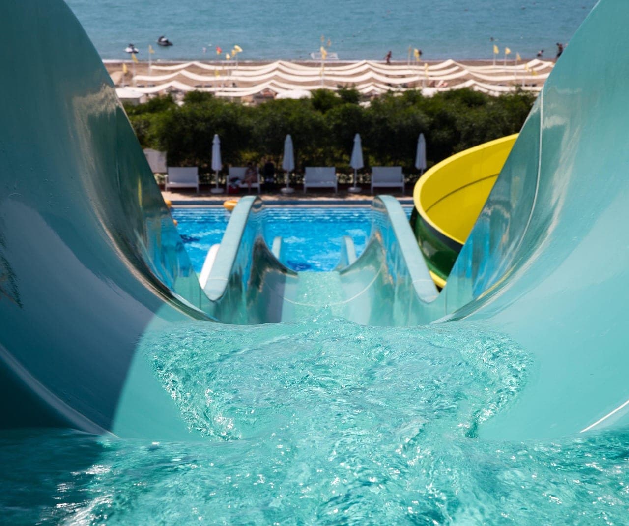 The top of a water slide, with the pool and the sea below.