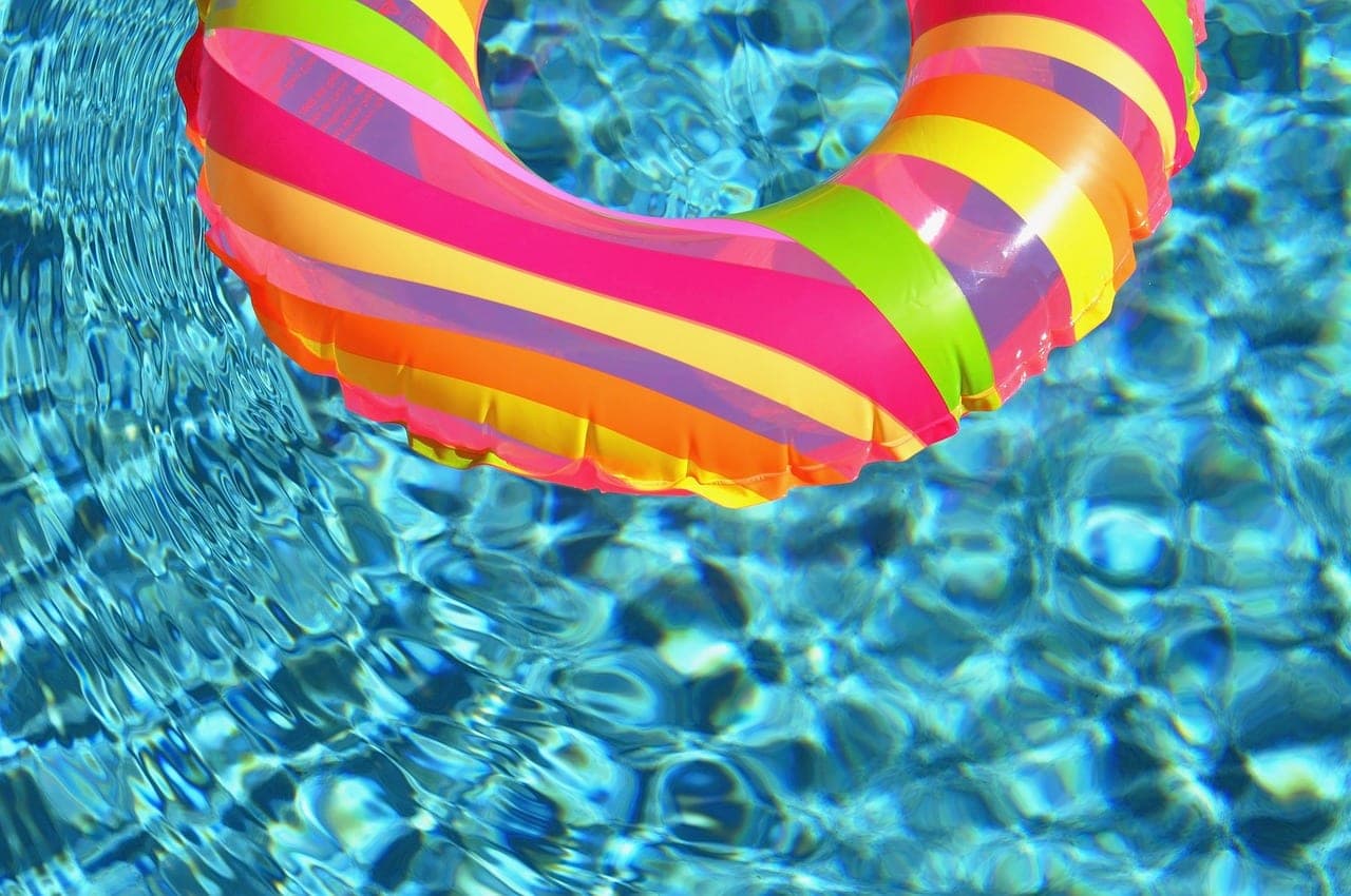 A striped inflatable ring on the clear water of a pool.