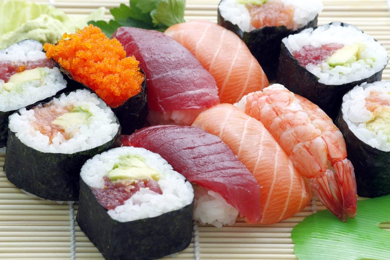 An assortment of sushi: tuna, salmon and shrimp nigiri, with maki rolls.