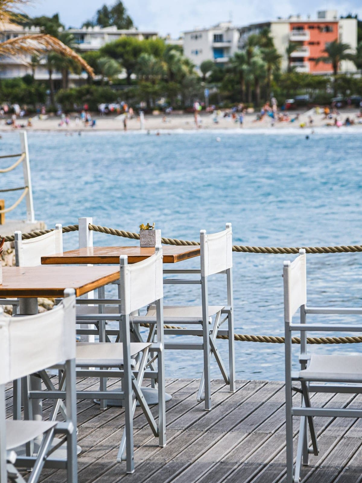 Tables and chairs on a deck, right at the water