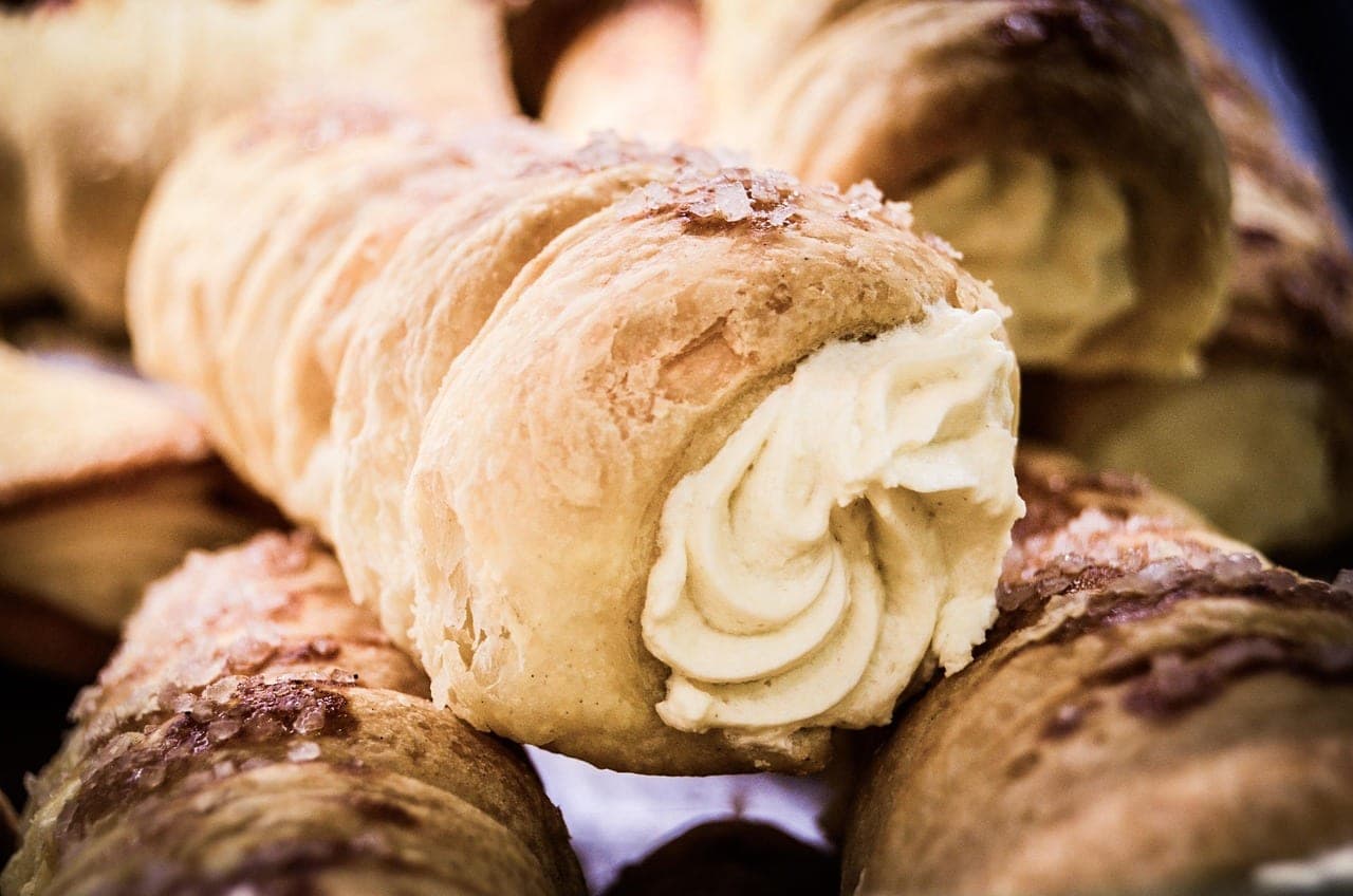 Rows of puff-pastry cream horns.