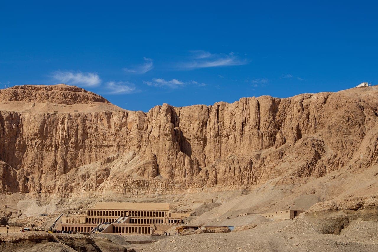 The temple, tiny at the foot of the Deir el-Bahari cliff.