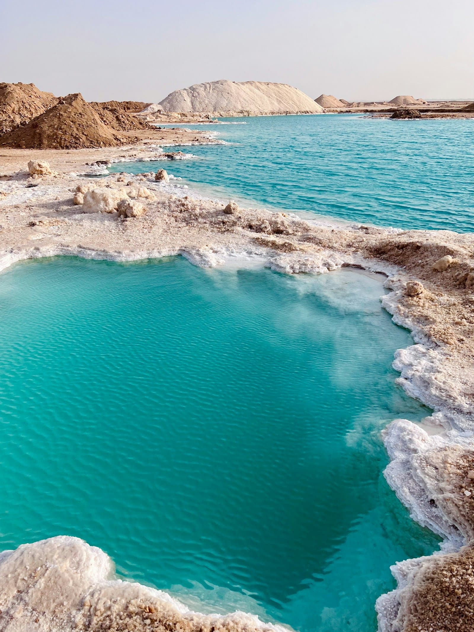 A salt lake: turquoise water, white crust all around.
